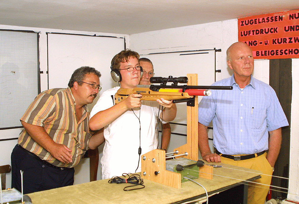 Bild 2: Michael mit dem Luftgewehr mit Zuschauern. Klaus Seger - Prsident des Hess. Schutzenbundes, Hans Kirch - Kreisschtzenmeister Hanau, Eilhardt Altenhofen - Vorsitzender der SSG